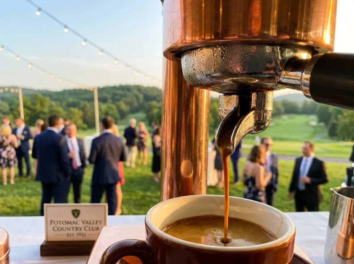 Close-up of an elegant espresso pour at a Potomac Maryland country club reception, championship golf course fairways and rolling hills softly blurred behind